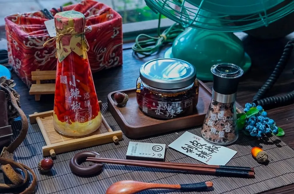 花蓮沈嬤嬤產品：紅色辣椒酒瓶、玻璃辣醬罐與研磨瓶，旁邊擺有筷子與花蓮沈嬤嬤名片