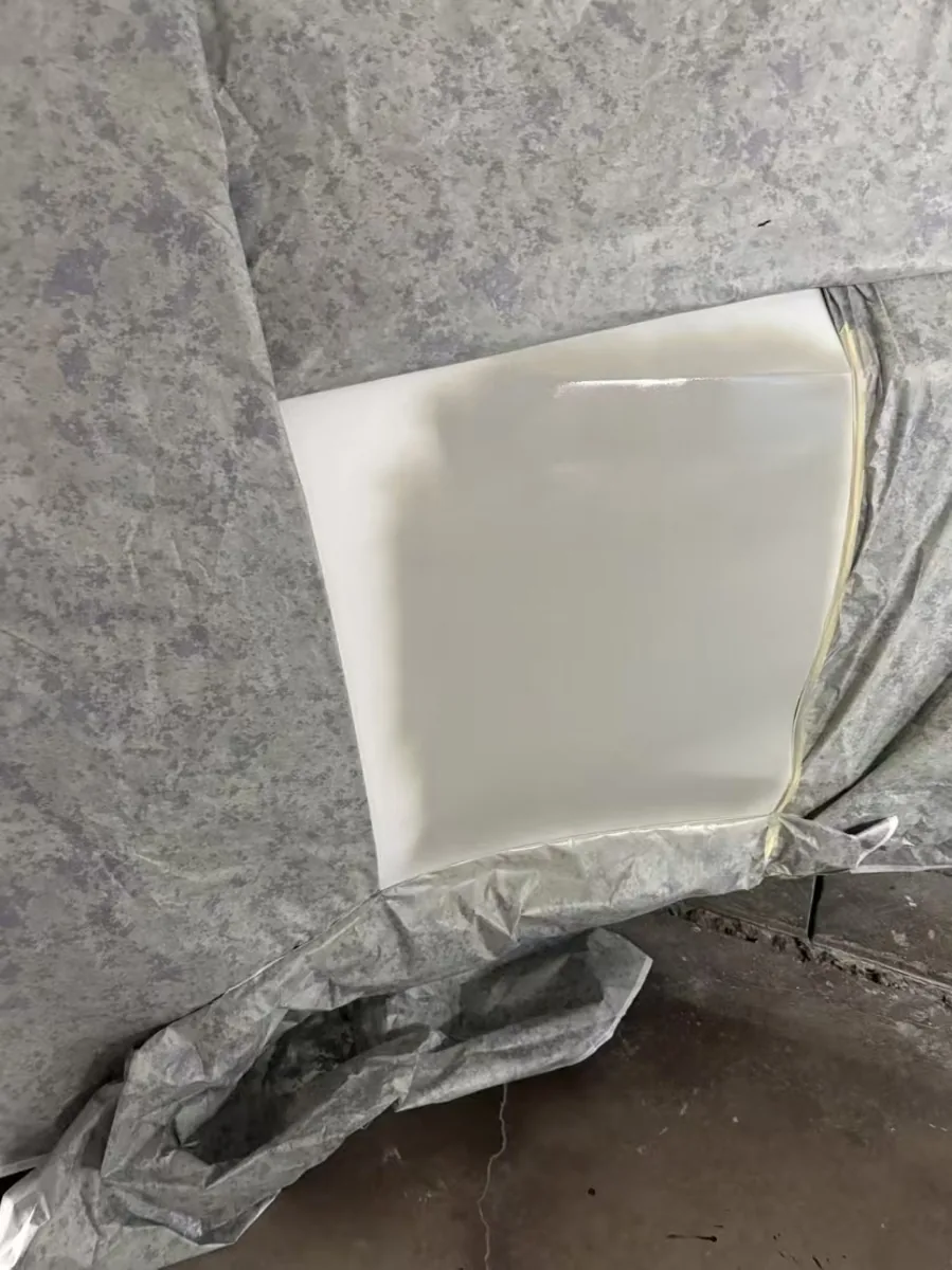 噴漆房內右後門局部用防護布遮蓋，露出剛噴好的珍珠白烤漆面近照