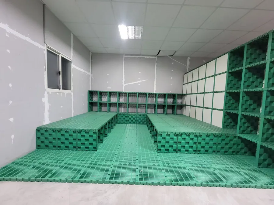 MECube無限方塊｜室內實拍綠色模組化地墊與高低平台，兩側排列模組櫃展示應用情境
