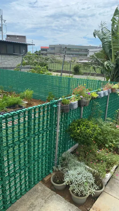 MECube無限方塊 戶外應用實拍：綠色模組化圍欄作為庭園隔柵，盆栽掛於圍欄邊緣