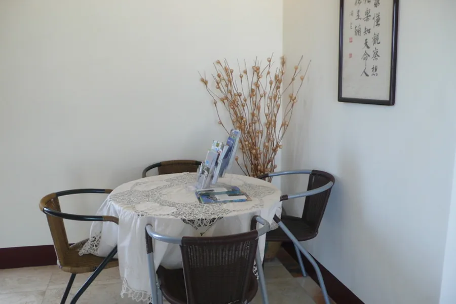 圓桌休憩區：覆以蕾絲桌巾的桌子與四張椅子，桌上豎立旅遊資訊與說明冊